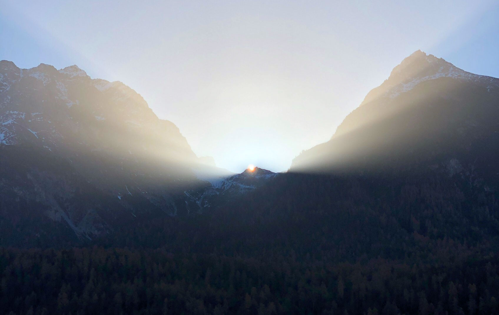 Berge-Sonnenaufgang-Gipfel Sonnenstrahlen die hinter den Berggipfeln aufsteigen